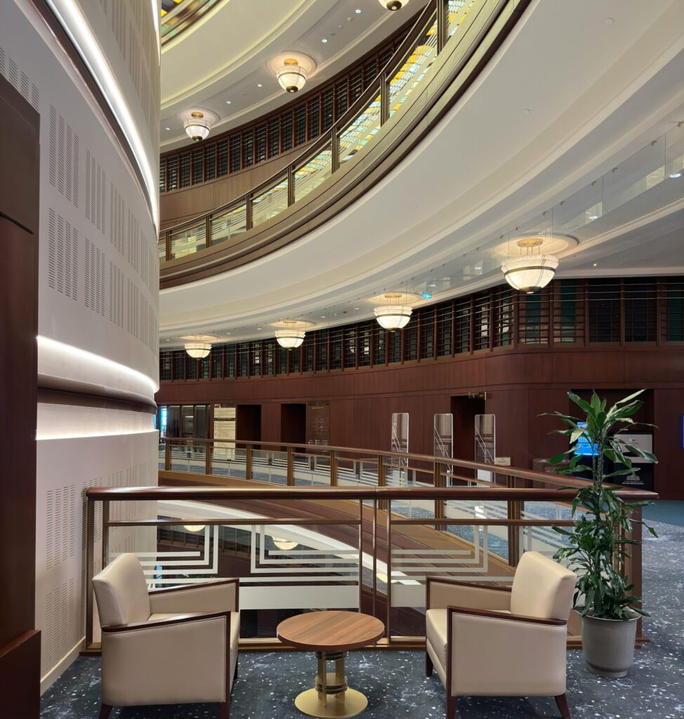 A luxurious modern hotel interior featuring stylish armchairs and a mezzanine view.
