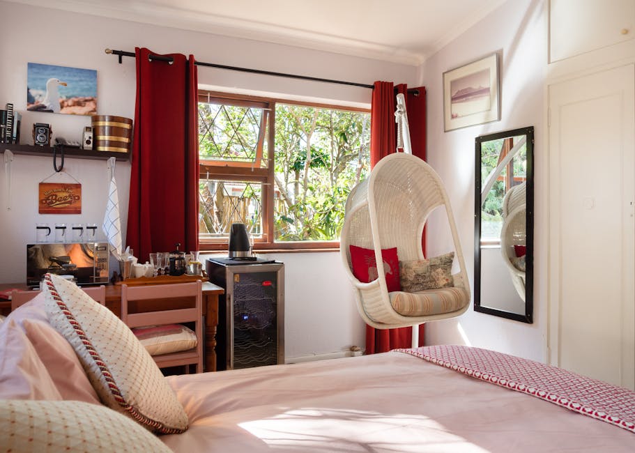 Bright bedroom interior featuring a swing chair, decorations, and furniture creating a cozy atmosphere.