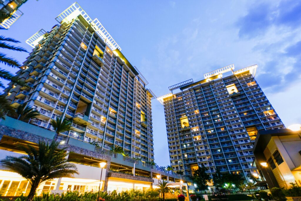 Tall residential towers with lights on during twilight, showcasing urban architecture.