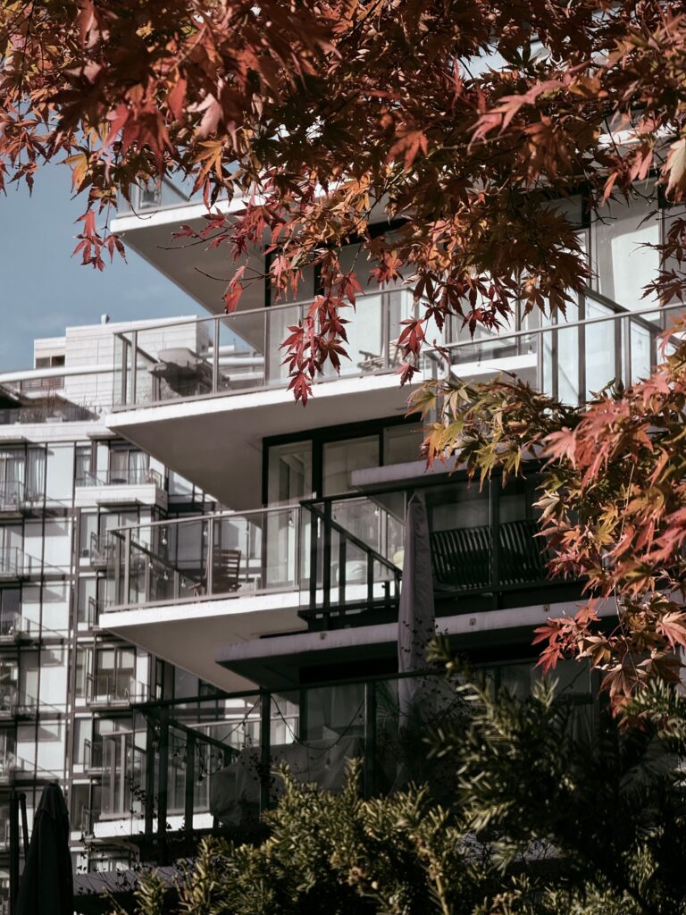 Contemporary apartment building with fall foliage in Vancouver, showcasing modern architecture and autumn colors.