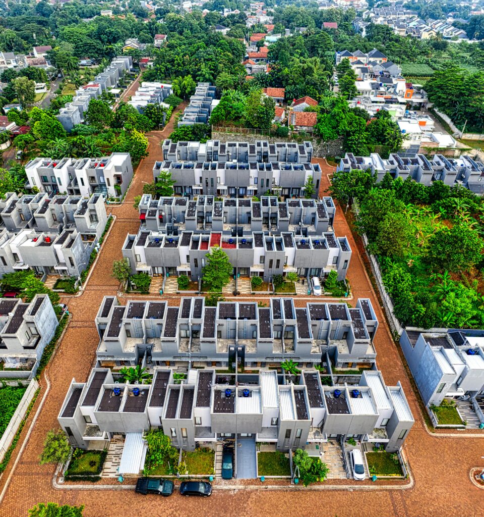 A vibrant aerial view capturing the modern residential complexes in Banten, Indonesia, amidst lush greenery.